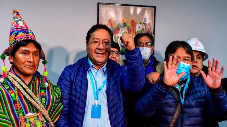 El candidato presidencial de Bolivia, Luis Arce (c), del partido Movimiento al Socialismo, celebra con su compañero de fórmula David Choquehuanca (d) a principios del 19 de octubre de 2020, en La Paz, Bolivia. (Foto de RONALDO SCHEMIDT/AFP vía Getty Images)
