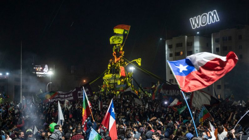 Manifestantes que apoyan la reforma de la Constitución chilena celebran los resultados oficiales del referéndum en la Plaza Italia de Santiago (Chile) el 25 de octubre de 2020. (Foto de PEDRO UGARTE/AFP vía Getty Images)