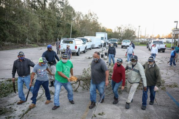 Trabajadores limpian los escombros del huracán Zeta en la escuela media de St Bernard el 29 de octubre de 2020 en St Bernard, Louisiana (EE.UU.). (Foto de Sandy Huffaker/Getty Images)