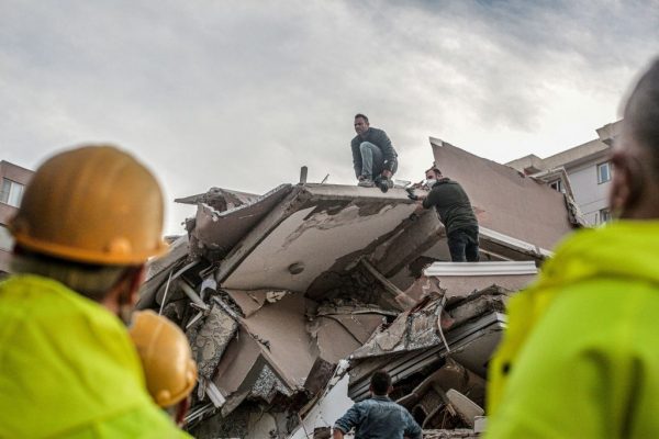 Voluntarios despejan los escombros mientras buscan supervivientes en un edificio derrumbado después de que un fuerte terremoto golpeara la costa occidental del país y partes de Grecia, matando a al menos cuatro personas e hiriendo a 152, en Izmir (Turquía), el 30 de octubre de 2020. (Foto de MERT CAKIR/AFP vía Getty Images)