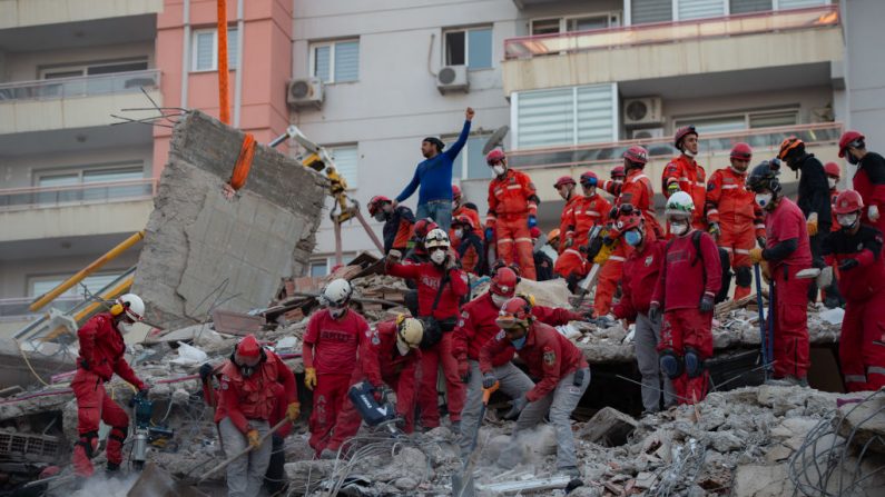 Voluntarios y personal de rescate buscan supervivientes en un edificio derrumbado en Izmir (Turquía), el 31 de octubre de 2020, después de que un fuerte terremoto sacudiera la costa occidental de Turquía y partes de Grecia. (Foto de YASIN AKGUL/AFP vía Getty Images)
