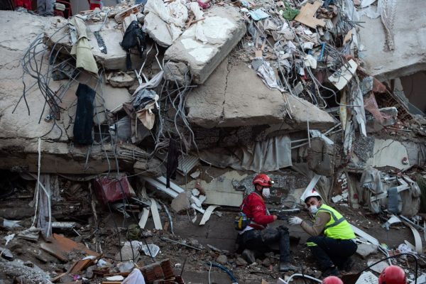 Voluntarios y personal de rescate buscan supervivientes en un edificio derrumbado en Izmir (Turquía), el 31 de octubre de 2020, después de que un fuerte terremoto sacudiera la costa occidental de Turquía y partes de Grecia. (Foto de YASIN AKGUL/AFP vía Getty Images)