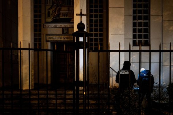 Agentes de policía examinan la entrada de la Iglesia ortodoxa donde un atacante armado con una escopeta recortada hirió a un sacerdote ortodoxo en un tiroteo antes de huir, el 31 de octubre de 2020 en Lyon (Francia). (Foto de JEFF PACHOUD / AFP a través de Getty Images)