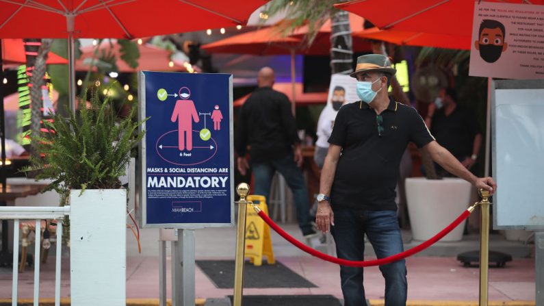 Juan Carlos, un anfitrión en el restaurante Ocean 10, se encuentra a la entrada del restaurante para rechazar a los clientes, ya que el 18 de julio de 2020 se establece un toque de queda de 8 p.m. a 6 a.m. en Miami Beach, Florida (EE.UU.). (Foto de Joe Raedle/Getty Images)
