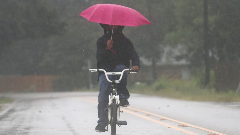 Un hombre monta bicicleta con un paraguas durante el huracán Delta el 9 de octubre de 2020 en Abbeville, Louisiana (EE.UU.). (Mario Tama/Getty Images)