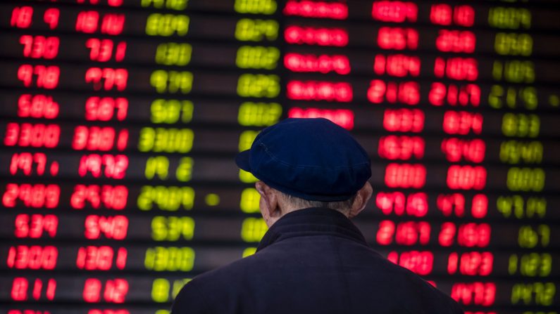 Un inversor mira un tablero electrónico que muestra información bursátil en una casa de bolsa en Shanghai el 16 de marzo de 2017. (JOHANNES EISELE/AFP a través de Getty Images)
