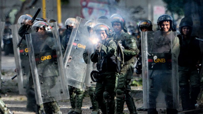 Un soldado de la Guardia Nacional con equipo antidisturbios dispara su escopeta a los manifestantes de la oposición durante los enfrentamientos que siguen a una protesta en contra del régimen de Nicolás Maduro en Caracas (Venezuela), el 26 de julio de 2017. (Federico Parra/AFP vía Getty Images)
