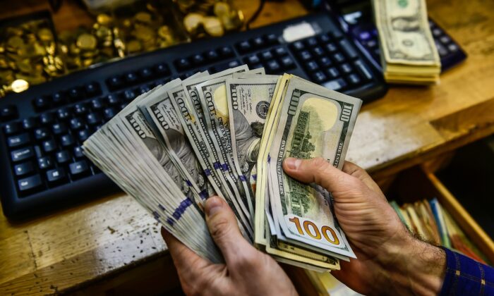 Un hombre estadounidense cuenta el dinero que sostiene en sus manos. Foto de archivo. (Yasin Akgul/AFP vía Getty Images)