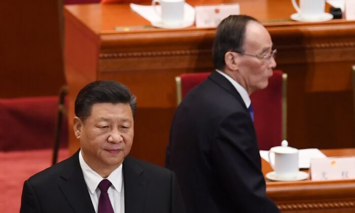 El líder chino, Xi Jinping (Izq.), se presenta cuando Wang Qishan (Der.), exsecretario de la Comisión Central de Inspección Disciplinaria, llega a la primera sesión del PCCh del 13° Congreso Nacional del Pueblo en Beijing, China, el 17 de marzo de 2018 (GREG BAKER / AFP a través de Getty Images)
