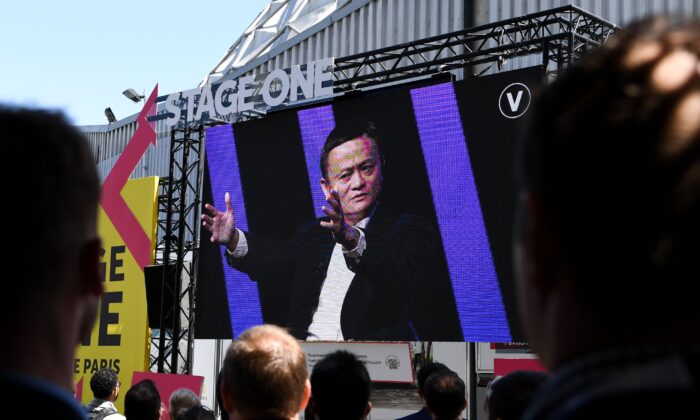 La gente ve en una pantalla gigante ubicada fuera del lugar de la Expo de París de Portes de Versaille, al CEO del grupo chino Alibaba, Jack Ma, hablando durante la feria de innovación y startups en Vivatech, en París el 16 de mayo de 2019. (ALAIN JOCARD/AFP a través de Getty Images)