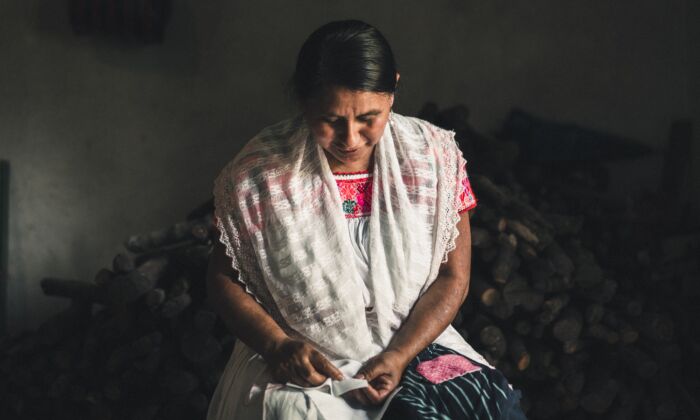 Artesana mexicana en Puebla cuenta las puntadas de su bordado a mano. (Someone Somewhere)