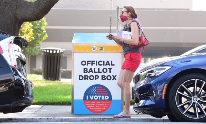 Una mujer con su boleta electoral pasa por delante de un buzón de voto para las elecciones de EE.UU. de 2020, en Monterey Park, California, el 5 de octubre de 2020. (Frederic J. Brown/AFP vía Getty Images)