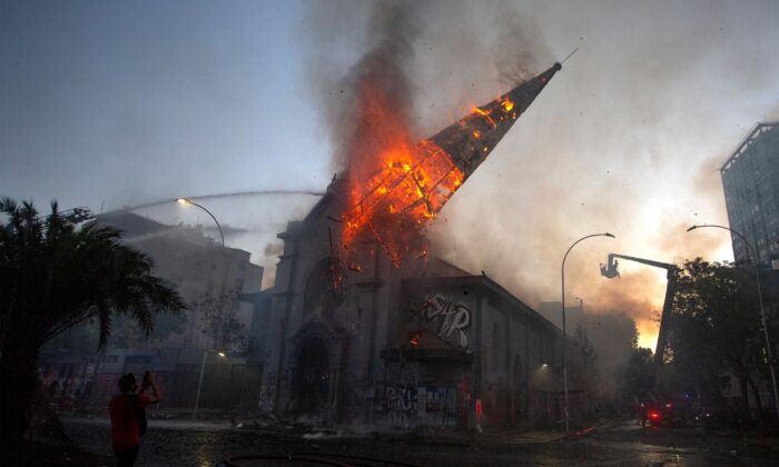 La cúpula de la iglesia de la Asunción cae ardiendo en llamas después que violentos alborotadores la incendiaran al cumplirse un año del estallido social en Chile, en Santiago, el 18 de octubre de 2020. (Claudio Reyes/AFP vía Getty Images)
