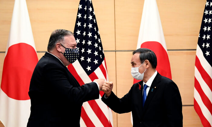 El primer ministro japonés Yoshihide Suga (derecha) y el secretario de Estado de EE.UU. Mike Pompeo (izquierda) se golpean los puños cuando se reúnen en la oficina del primer ministro en Tokio, el 6 de octubre de 2020. (Charly Triballeau/POOL/AFP vía Getty Images)