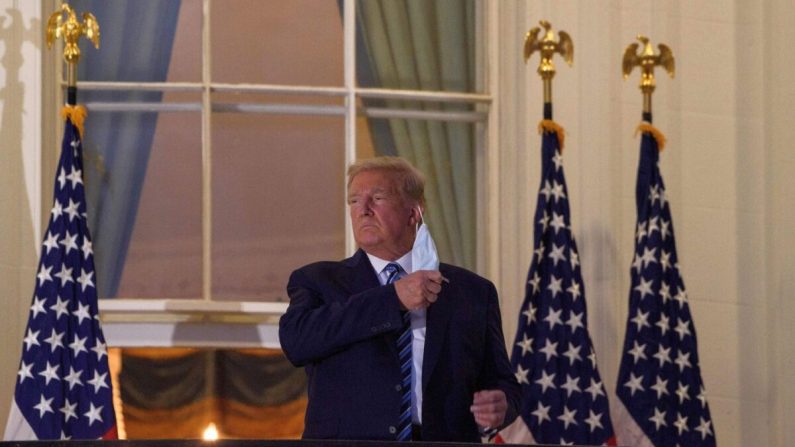 El presidente de Estados Unidos, Donald Trump, se quita la mascarilla al llegar a la Casa Blanca a su regreso del Centro Médico Walter Reed, donde se sometió al tratamiento del virus del PCCh, en Washington, el 5 de octubre de 2020. (Nicholas Kamm/AFP vía Getty Images)