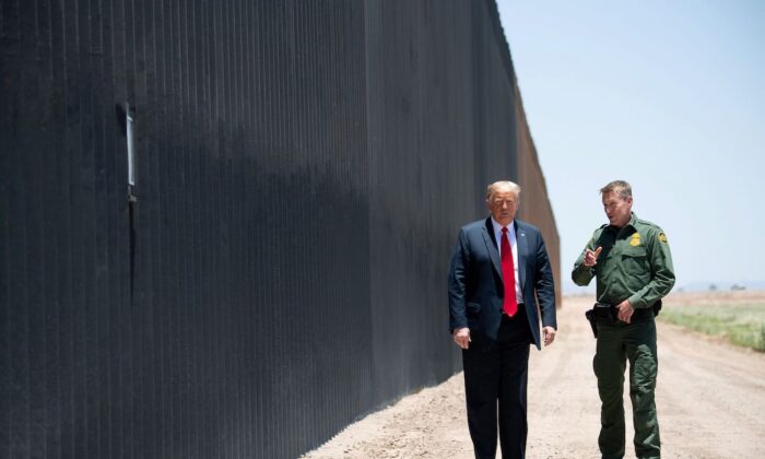 El presidente d EStados Unidos, Donald Trump, habla con el Jefe de la Patrulla Fronteriza, Rodney Scott (R), mientras participan en una ceremonia conmemorativa de las 200 millas de muro fronterizo en la frontera internacional con México en San Luis, Arizona, el 23 de junio de 2020. (Saul Loeb/AFP vía Getty Images)