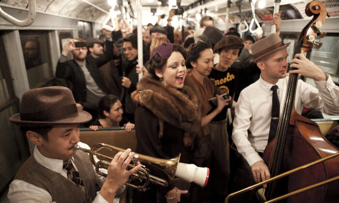 Pasajeros llevan ropa de épocas pasadas en los vagones del metro de Nueva York el 8 de diciembre de 2013. (Samira Bouaou/Epoch Times)