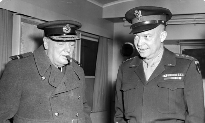 14 de noviembre de 1944: el primer ministro británico Winston Churchill fuma un puro y escucha mientras el general Dwight D. Eisenhower, comandante supremo aliado, le muestra su remolque, en la Segunda Guerra Mundial. (Archivo Hulton/Getty Images)