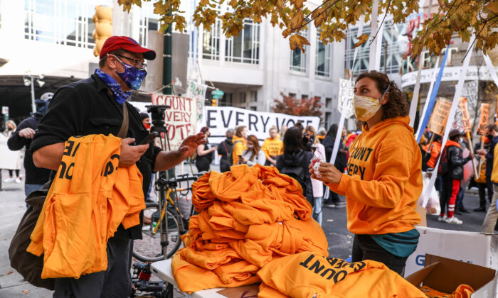 El Partido de las Familias Trabajadoras reparte sudaderas con capucha amarillas que dicen "Cuenten Cada Voto" en el Centro de Convenciones de Pensilvania en Filadelfia, Pensilvania, el 6 de noviembre de 2020. (Charlotte Cuthbertson/The Epoch Times)