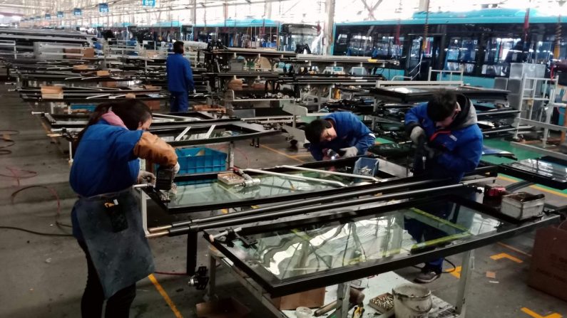 Trabajadores chinos construyen piezas para un autobús eléctrico en una fábrica de Liaocheng, en la provincia china de Shandong, el 12 de diciembre de 2018. (STR/AFP/Getty Images)
