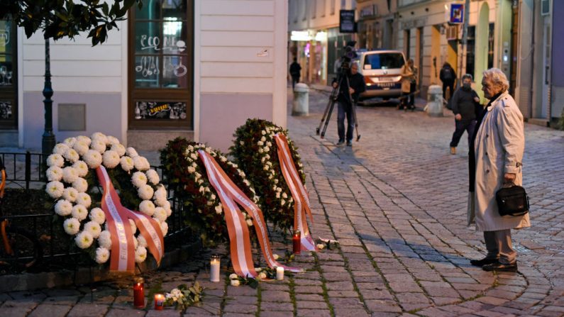 Una peatona se detiene ante las coronas de flores colocadas por el Gobierno austriaco en la escena del crimen en el centro de la ciudad el día después de un tiroteo mortal el 3 de noviembre de 2020 en Viena, Austria. (Foto de Thomas Kronsteiner / Getty Images)