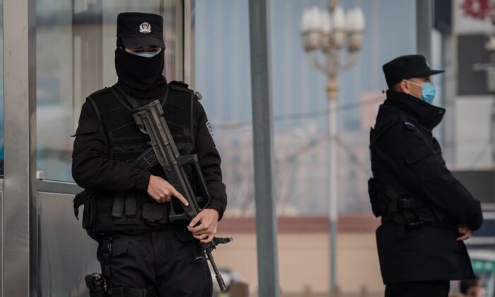 Oficiales de policía con el rostro cubierto aseguran un área en la estación de tren de Beijing el 27 de enero de 2020. (Nicolas Asfouri/AFP vía Getty Images)