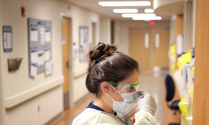 Una enfermera de la unidad COVID-19 del MedStar St. Mary's Hospital verifica el ajuste del equipo de protección antes de ingresar a la habitación de un paciente en Leonardtown, Maryland, el 24 de marzo de 2020. (Win McNamee/Getty Images)