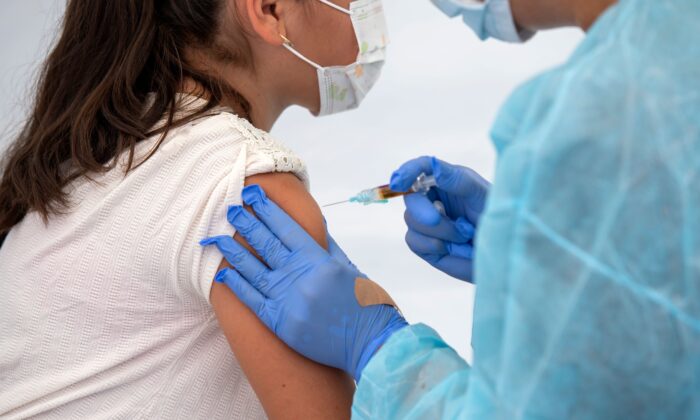 Un trabajador de la salud vacuna a una estudiante durante una jornada de salud comunitaria en Los Ángeles, el 12 de agosto de 2020. (Valerie Macon/AFP a través de Getty Images)
