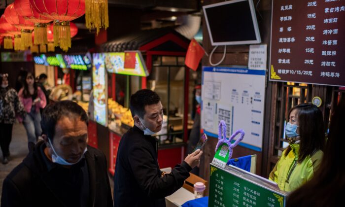 Un cliente (centro) escanea un código de pago QR para pagar en un restaurante en Beijing, el 28 de octubre de 2020. (NICOLAS ASFOURI/AFP a través de Getty Images)