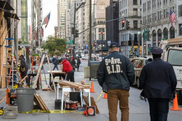 Empleado y guardia de seguridad pasan junto a un equipo de trabajadores que abordan una tienda en anticipación de los disturbios relacionados con las elecciones presidenciales, el 2 de noviembre de 2020 en la ciudad de Nueva York (EE.UU.). (Foto de David Dee Delgado / Getty Images)