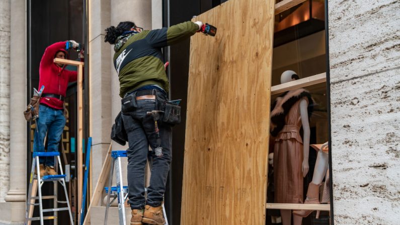 Los trabajadores abordan una tienda en previsión de los disturbios relacionados con las elecciones presidenciales, el 2 de noviembre de 2020 en la ciudad de Nueva York (EE.UU.). (Foto de David Dee Delgado / Getty Images)