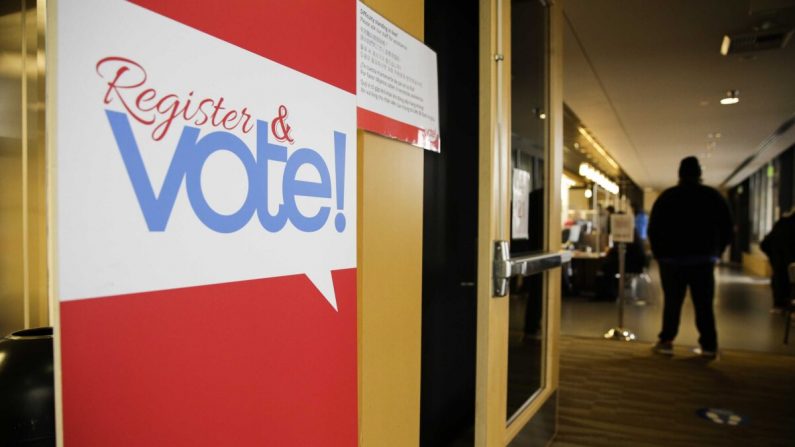 Un cartel para el registro de votantes se muestra el día de las elecciones en la oficina de elecciones del condado de King en Renton, Washington, el 3 de noviembre de 2020. (Jason Redmond/AFP vía Getty Images)
