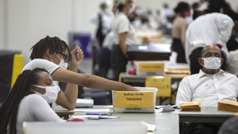 Un trabajador del Departamento de Elecciones de Detroit clasifica los votos en ausencia en la Junta Central de Conteo en el Centro TCF en Detroit, Mich., el 4 de noviembre de 2020. (Elaine Cromie/Getty Images)