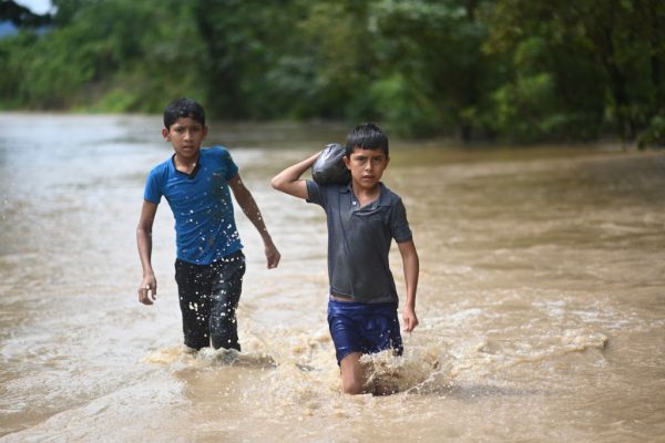 Niños vadeando el agua en un área inundada en Panzos, Alta Verapaz, 220 km al norte de la Ciudad de Guatemala el 6 de noviembre de 2020 después del paso del huracán Eta, ahora degradado a tormenta tropical. (Foto de JOHAN ORDONEZ / AFP a través de Getty Images)