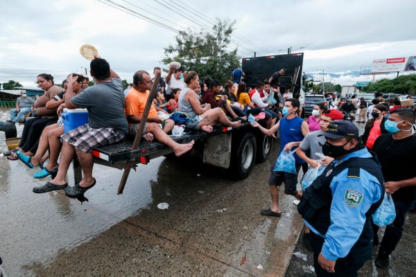 Cientos de personas son transportadas en un camión mientras reciben agua y comida de voluntarios el 6 de noviembre de 2020 en Cortes, Honduras. (Foto de Yoseph Amaya / Getty Images)