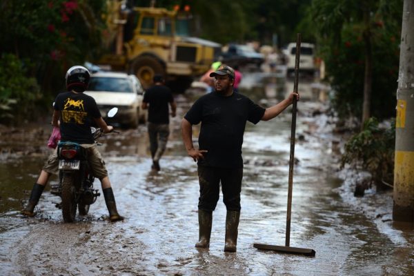 Un hombre hace una pausa mientras limpia el lodo tras el paso del huracán Eta en el municipio de Villanueva, departamento de Cortés, Honduras, el 7 de noviembre de 2020. (Foto de ORLANDO SIERRA / AFP vía Getty Images)