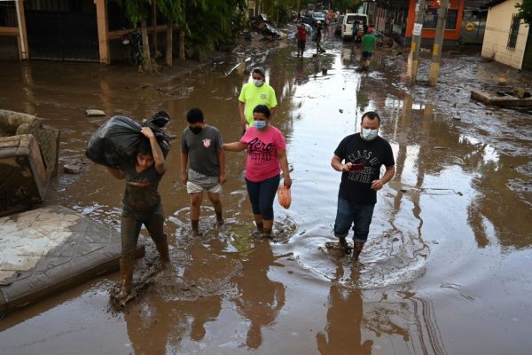 Personas vadean un área inundada luego del paso del huracán Eta en el municipio de Villanueva, departamento de Cortés, Honduras, el 7 de noviembre de 2020. (Foto de ORLANDO SIERRA / AFP vía Getty Images)