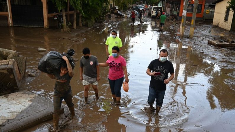 Personas vadean un área inundada luego del paso del huracán Eta en el municipio de Villanueva, departamento de Cortés, Honduras, el 7 de noviembre de 2020. (Foto de ORLANDO SIERRA / AFP vía Getty Images)