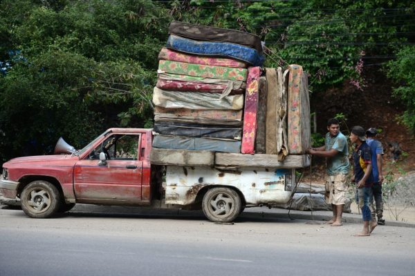 Hombres cargan colchones en una camioneta pick-up luego del paso del huracán Eta en el municipio de Villanueva, departamento de Cortés, Honduras, el 7 de noviembre de 2020. (Foto de ORLANDO SIERRA / AFP vía Getty Images)