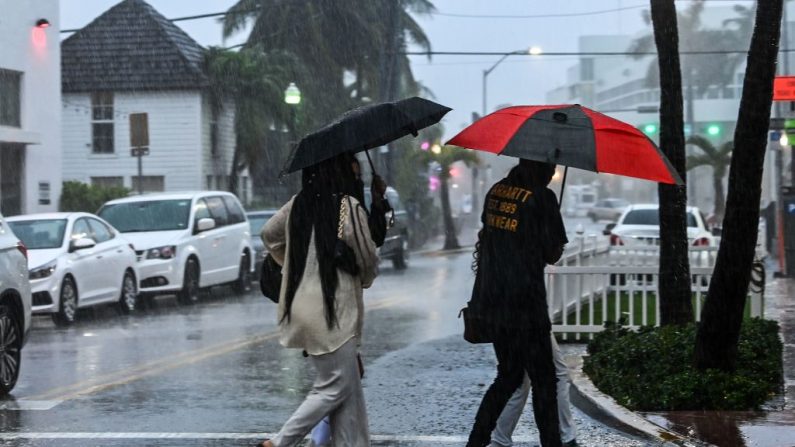 La gente cruza la calle durante una fuerte lluvia y viento mientras la tormenta tropical Eta se acerca al sur de Florida, en Miami, Florida el 8 de noviembre de 2020. (Chandan Khanna / AFP vía Getty Images)
