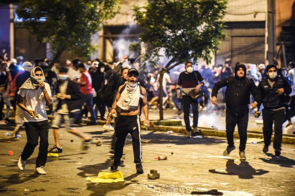 Manifestantes enfrentan a la policía antidisturbios durante una protesta contra el nuevo gobierno del presidente interino Manuel Merino, luego del juicio político y destitución del expresidente peruano Martín Vizcarra, en la plaza San Martín de Lima (Perú) el 12 de noviembre de 2020. (Foto de ERNESTO BENAVIDES / AFP a través de Getty Images)