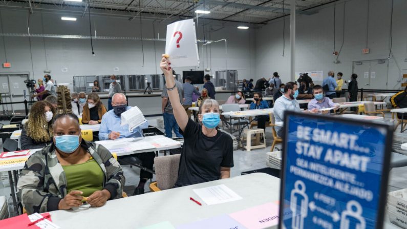 Una trabajadora del Condado de Gwinnett levanta un trozo de papel que indica que tiene una pregunta al comienzo del recuento de boletas en Lawrenceville, Georgia, el 13 de noviembre de 2020. (Megan Varner/Getty Images)