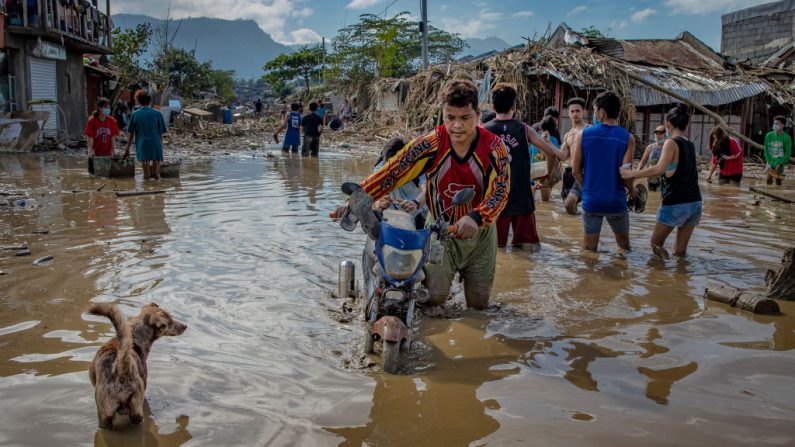 Los residentes caminan a través del agua fangosa que sumergió una aldea después del tifón Vamco golpeó el 14 de noviembre de 2020 en Rodríguez, provincia de Rizal, Filipinas. (Foto de Ezra Acayan / Getty Images)