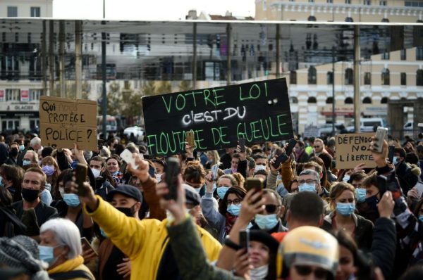 Los manifestantes sostienen un cartel con un juego de palabras que usa la palabra "difuminar" para leer "Esto es una burla" durante una protesta en el Vieux-Port, convocado por el movimiento "Chalecos amarillos" (Gilets Jaunes) para protestar contra el proyecto de ley de "seguridad global" que busca limitar la filmación de agentes de policía en servicio, en Marsella (Francia), el 21 de noviembre de 2020. (Foto de CLEMENT MAHOUDEAU / AFP a través de Getty Images)
