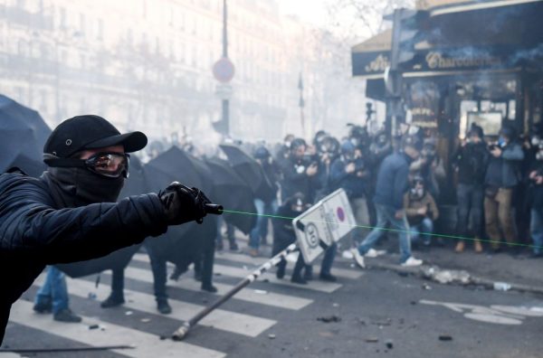 Un manifestante apunta con una luz láser durante una protesta contra el proyecto de ley de 'seguridad global', cuyo artículo 24 tipificaría como delito la publicación de imágenes de policías en servicio con la intención de dañar su 'integridad física o psicológica', en París (Francia), el 28 de noviembre de 2020. (Foto de ALAIN JOCARD / AFP a través de Getty Images)