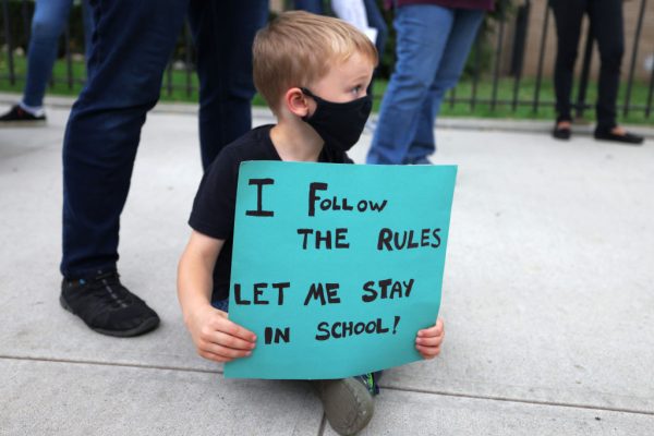 Maddux DeBlasio Olsheski, de 5 años, sostiene un cartel durante una conferencia de prensa el 7 de octubre de 2020 en la ciudad de Nueva York. Los padres de estudiantes en Forest Hills, Rego Park y Kew Gardens se reunieron para protestar contra la orden del gobernador Andrew Cuomo de cerrar escuelas en nueve códigos postales de Brooklyn y Queens, donde ha habido un aumento en los casos de covid-19. (Foto de Michael M. Santiago / Getty Images)