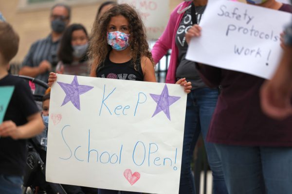 Una niña sostiene un cartel durante una conferencia de prensa el 7 de octubre de 2020 en la ciudad de Nueva York. Los padres de estudiantes en Forest Hills, Rego Park y Kew Gardens se reunieron para protestar contra la orden del gobernador Andrew Cuomo de cerrar escuelas en nueve códigos postales de Brooklyn y Queens, donde ha habido un aumento en los casos del covid-19. (Foto de Michael M. Santiago / Getty Images)