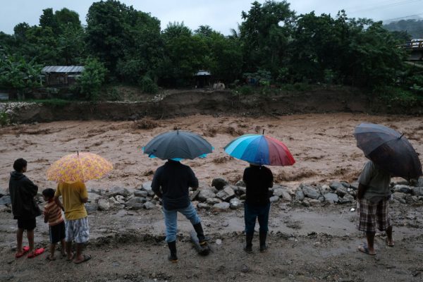 Los residentes locales observan la marea alta del río Guaymita producida por la tormenta tropical Eta el 4 de noviembre de 2020 en Yoro, Honduras. (Foto de Yoseph Amaya / Getty Images)