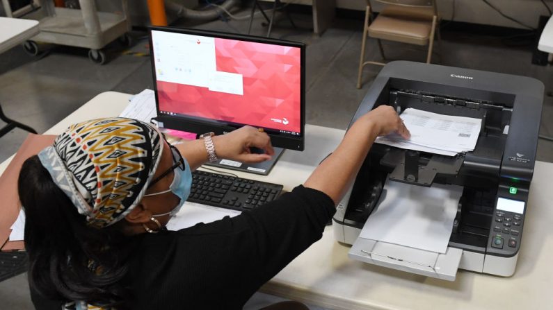 Una trabajadora electoral del condado de Clark escanea los votos por correo en el Departamento de Elecciones del condado de Clark el 4 de noviembre de 2020 en el norte de Las Vegas, Nevada. (Ethan Miller/Getty Images)