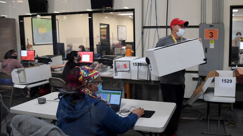 Los trabajadores electorales del condado de Clark escanean las boletas de correo frente a una sala de contabilización en el Departamento de Elecciones del condado de Clark el 7 de noviembre de 2020 en el norte de Las Vegas, Nevada. (Ethan Miller/Getty Images)